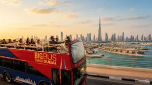 Big Bus Company Dubai sightseeing bus passing Burj Khalifa and Dubai Mall with tourists enjoying a hop-on hop-off city tour of Dubai's famous landmarks in 2026.