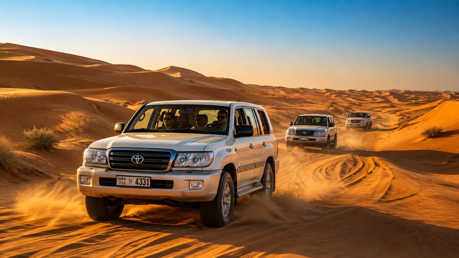 A line of white Toyota Land Cruisers driving through the scenic golden dunes of the Arabian desert