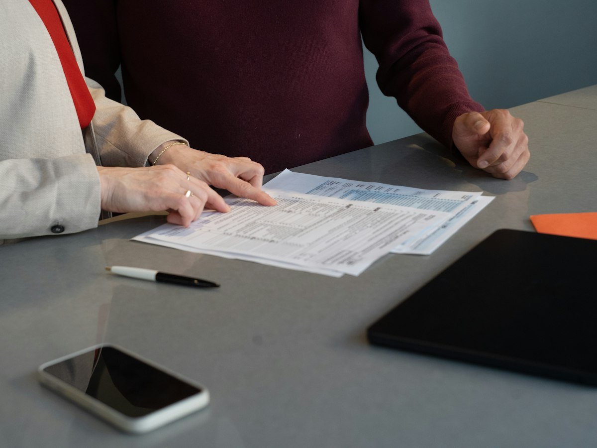 Two professionals reviewing paperwork at a conference table